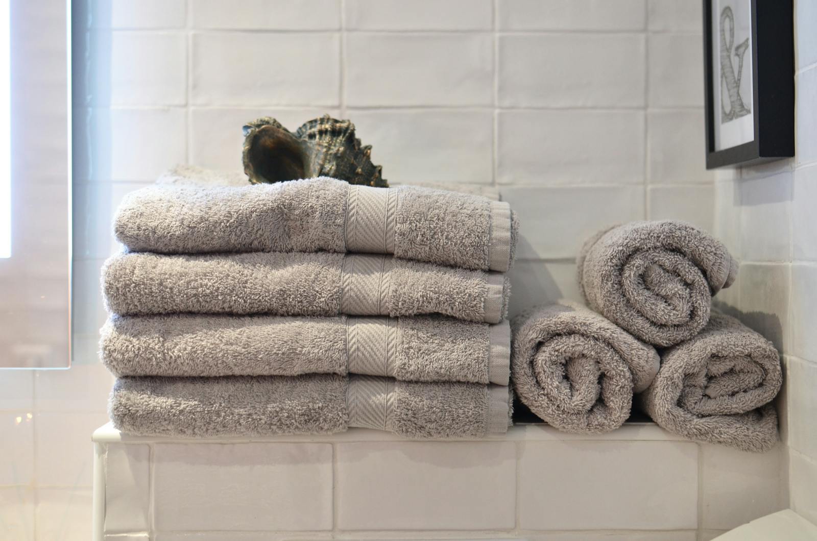 Neutral towels arranged for bed and bath essentials
